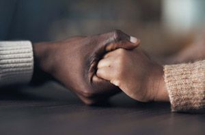 A man and a woman are holding hands on a table.
