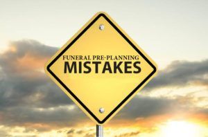 A yellow sign that says funeral pre-planning mistakes