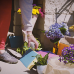 A person is standing next to a table with flowers on it.
