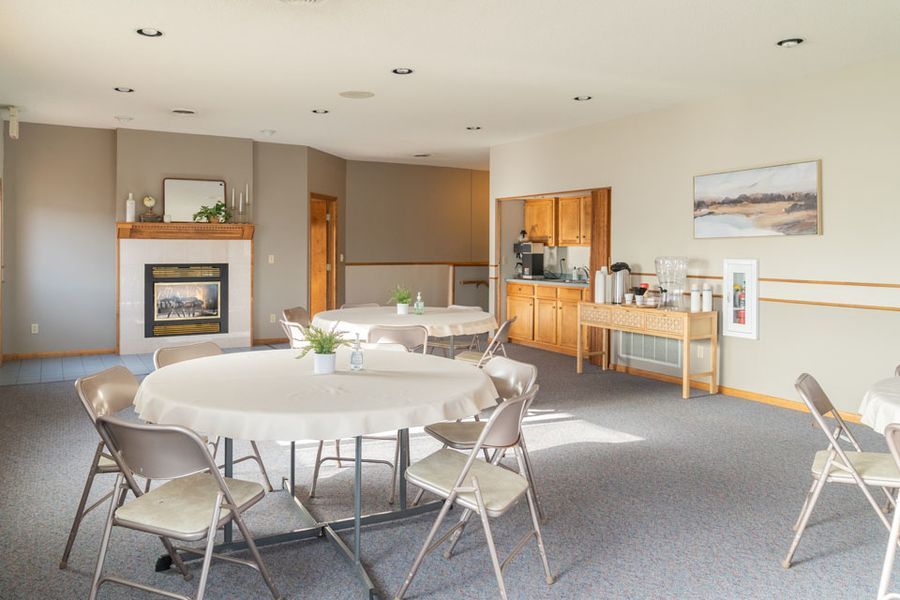 A large room with tables and chairs and a fireplace in Ellsworth
