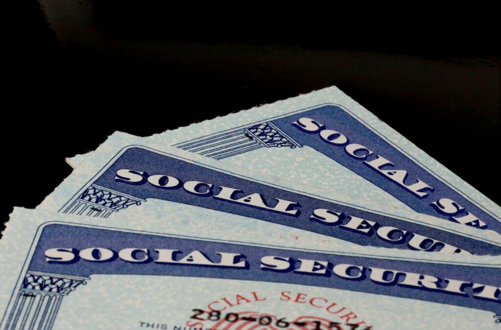 Three social security cards are stacked on top of each other