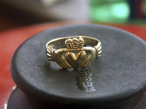 A gold claddagh ring with a crown on top of it