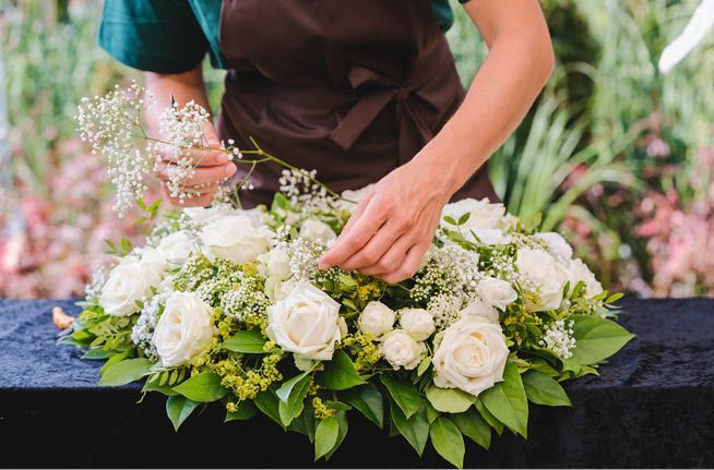 A woman is arranging flowers on a table.