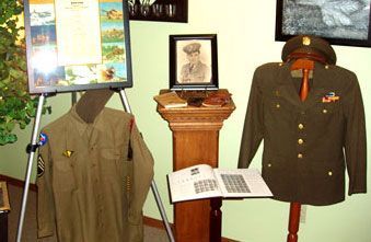A display of military uniforms and a picture of a man