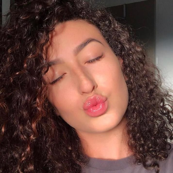 A Woman With Curly Hair Is Blowing A Kiss With Her Eyes Closed — It's All About Brows In Varsity Lakes, QLD