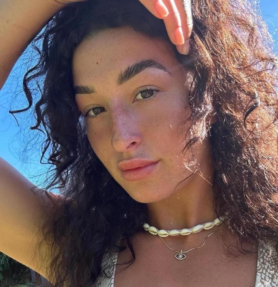 A Woman With Curly Hair Is Wearing A Pearl Necklace — It's All About Brows In Varsity Lakes, QLD