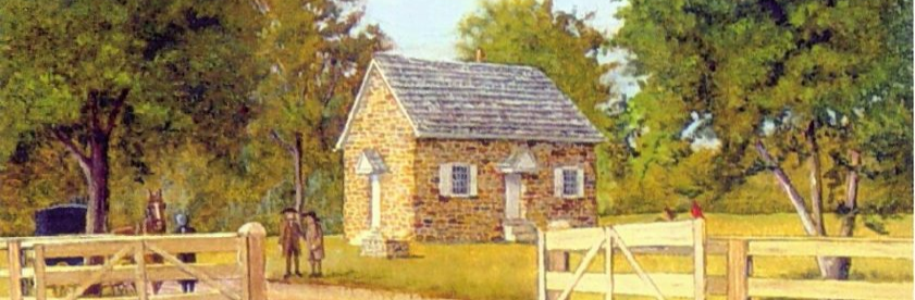 Stone Meeting house surrounded by trees and wooden fences. 