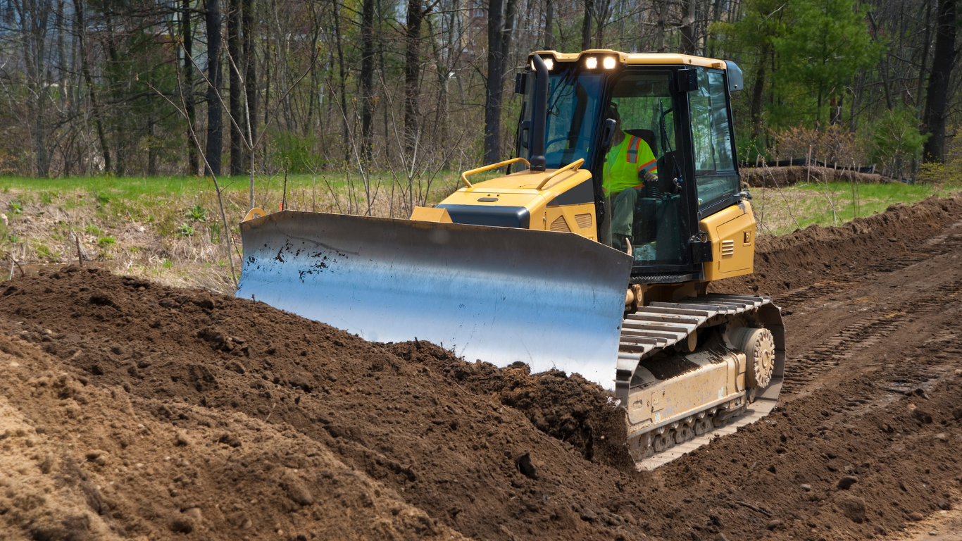 A couple of Tailored Excavation excavators are working on a dirt field.