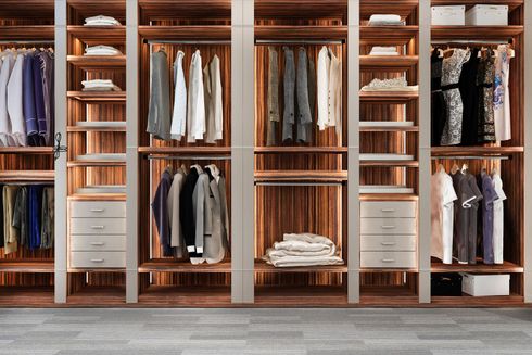 Built-in wooden closet with shelves, hanging clothes, folded items, and drawers