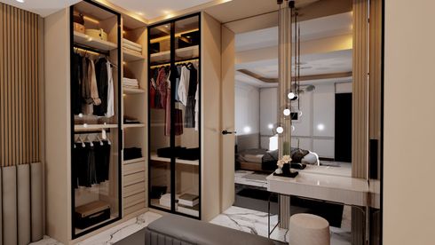 Walk-in closet with beige wardrobes, mirrored panels, and a vanity table under warm lighting.