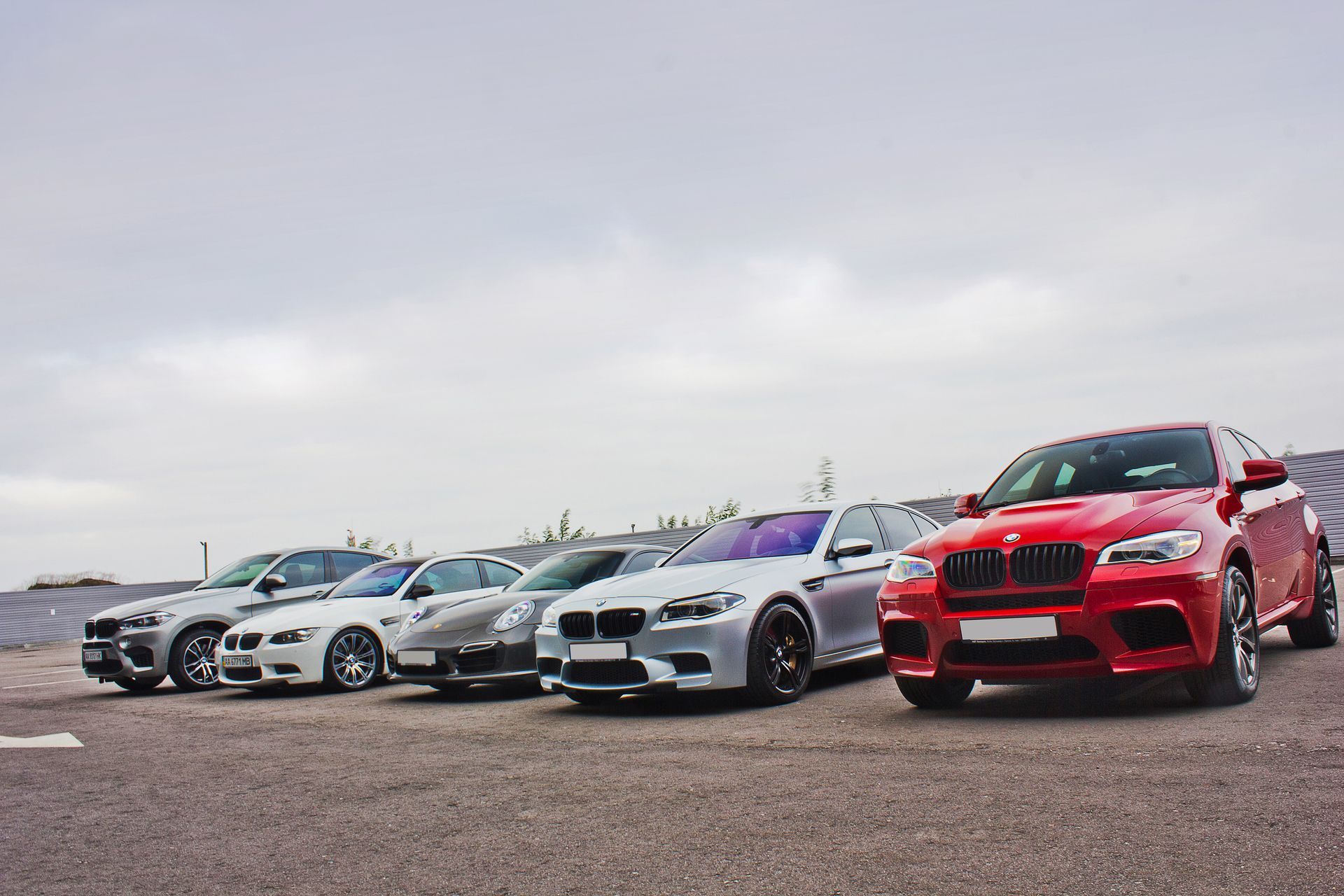A row of bmw cars are parked in a parking lot.