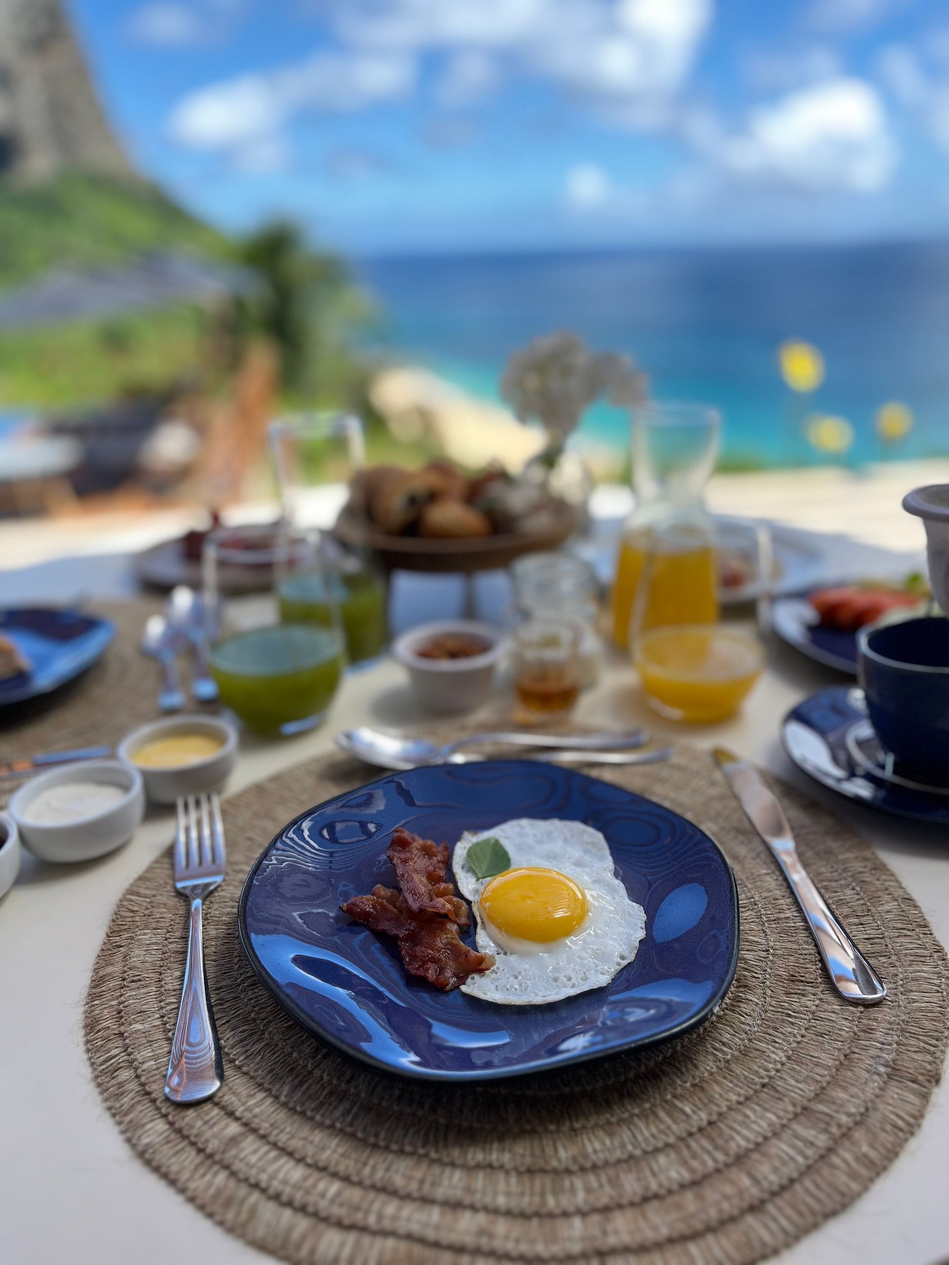 Um prato azul com um ovo frito e bacon