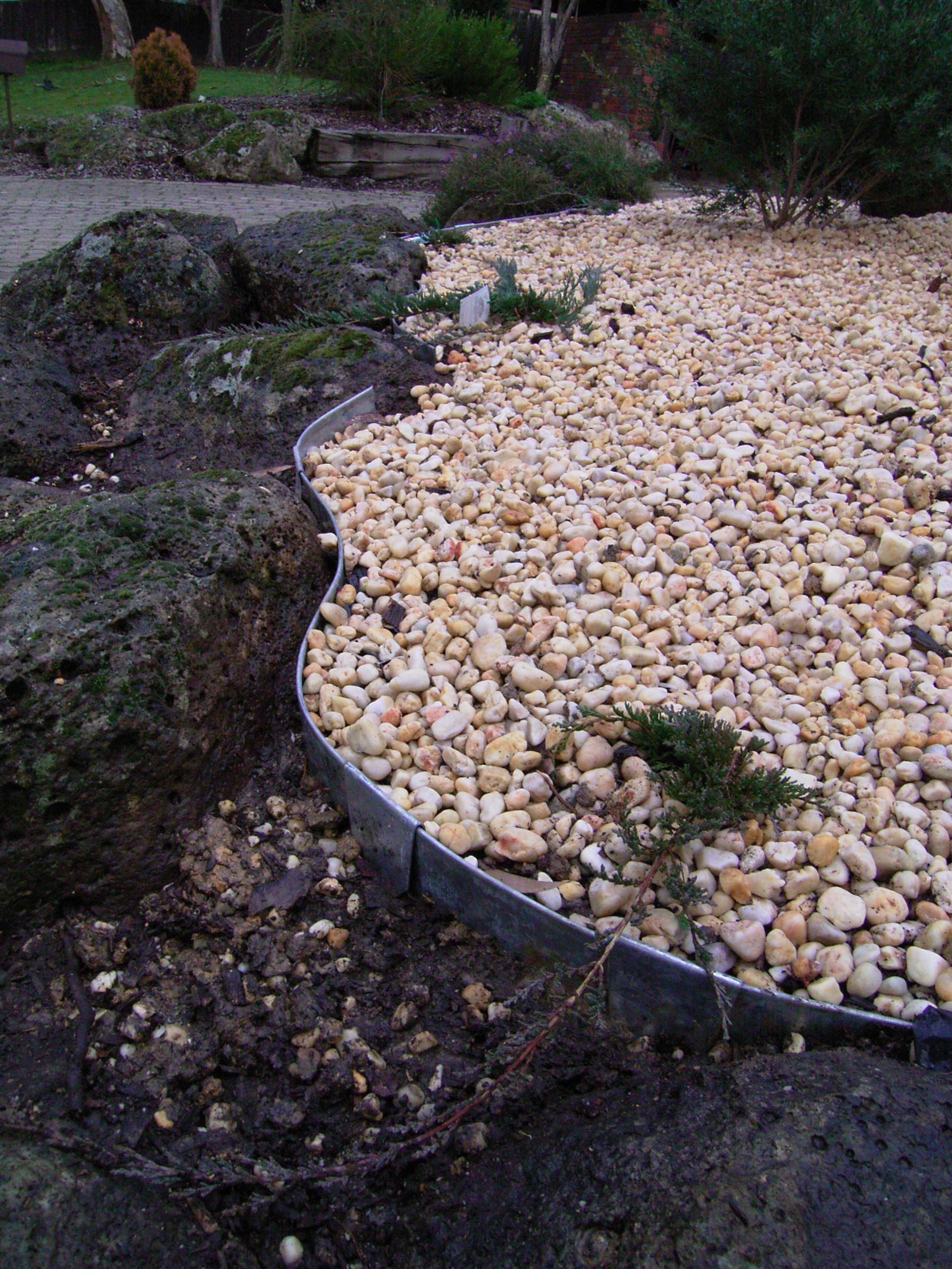 Landscape with rocks, gravel, and metal edging.