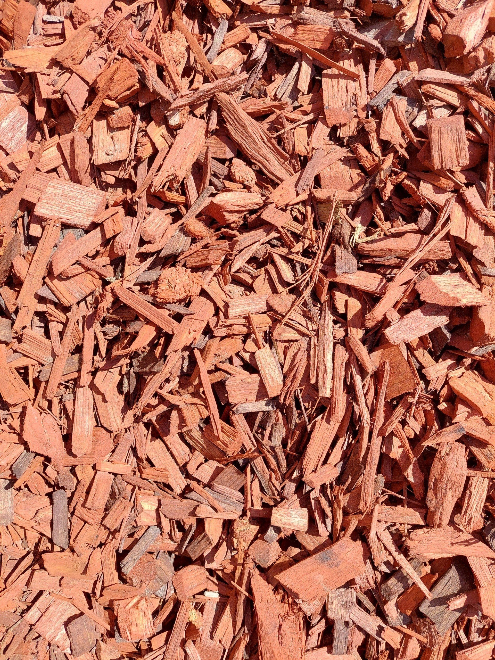 Reddish-brown wood mulch covering the ground, made up of various sized pieces.