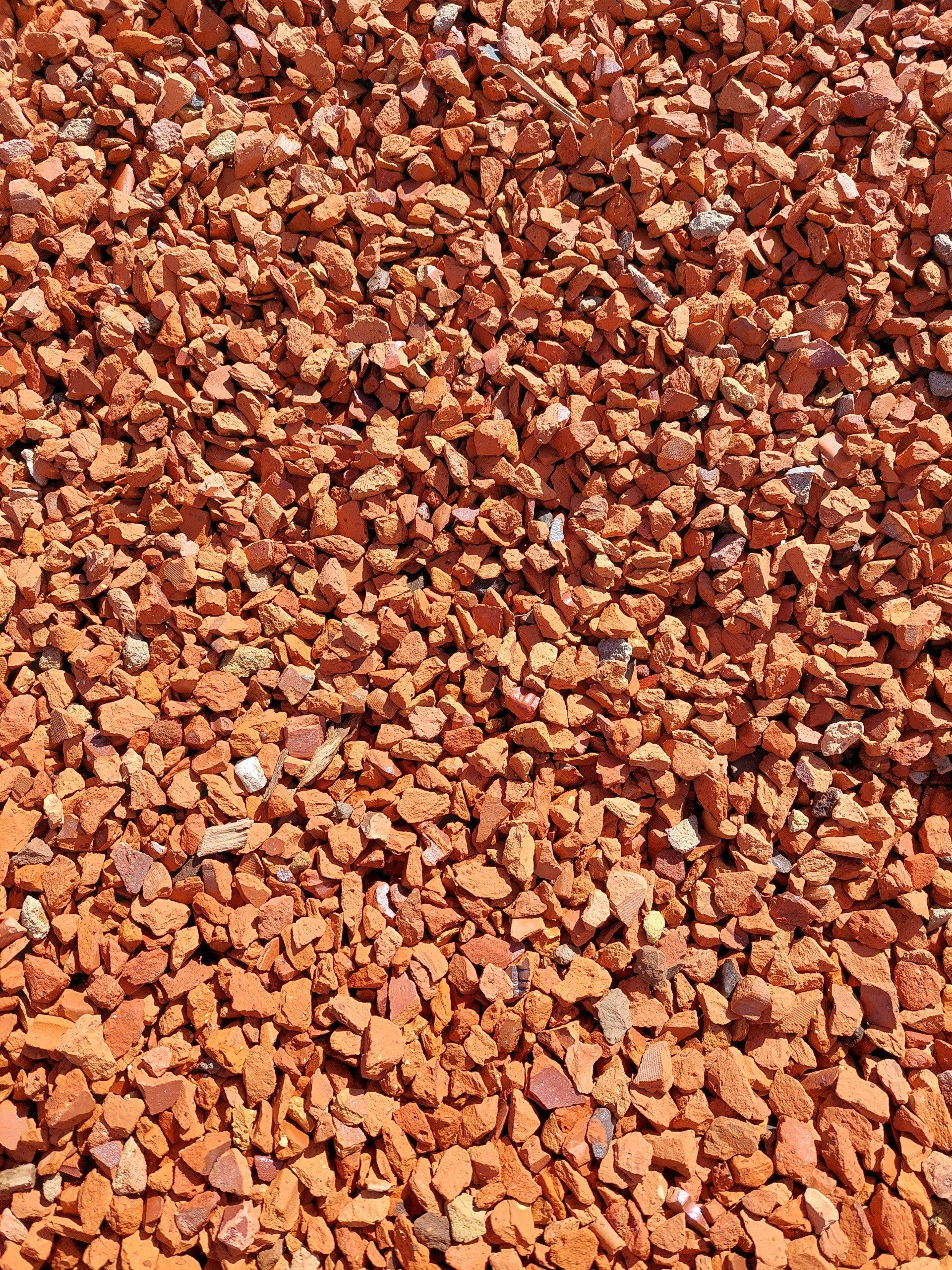 Crushed red brick pieces, small and irregular, filling the frame.