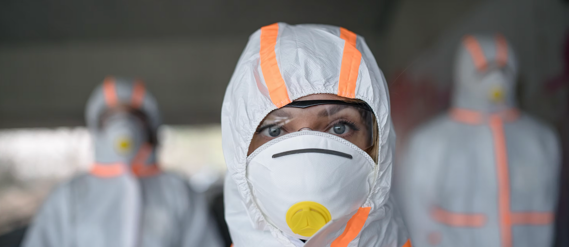 A group of people wearing protective suits and masks.