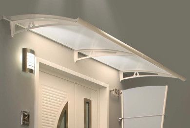Tenda da sole bianca moderna sopra la porta d'ingresso di una casa beige