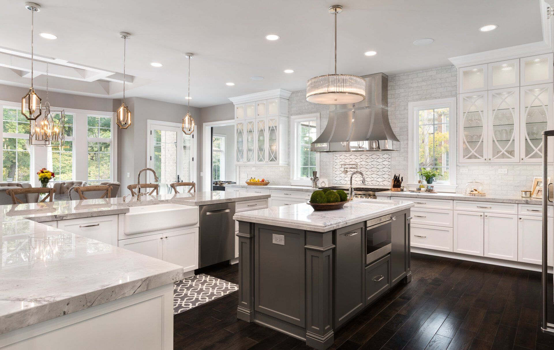 A large kitchen with white cabinets and a large island in the middle.