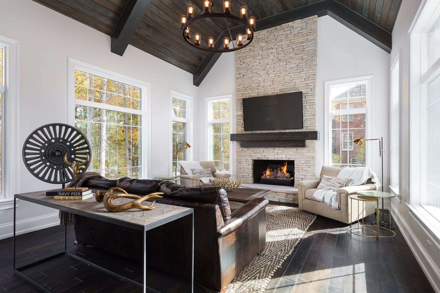 A living room with a fireplace , couch , chairs , table and television.