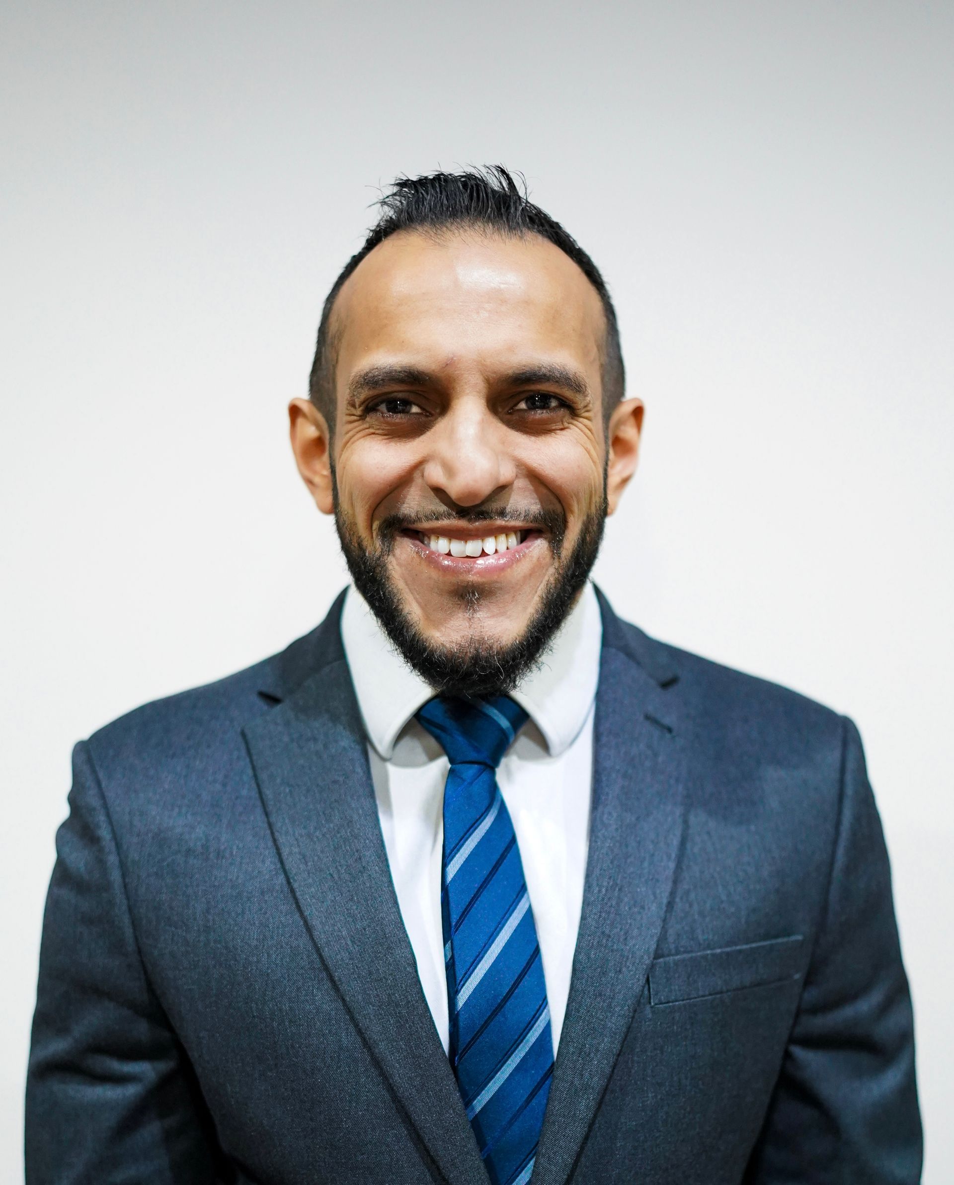 A man in a suit and tie is smiling for the camera