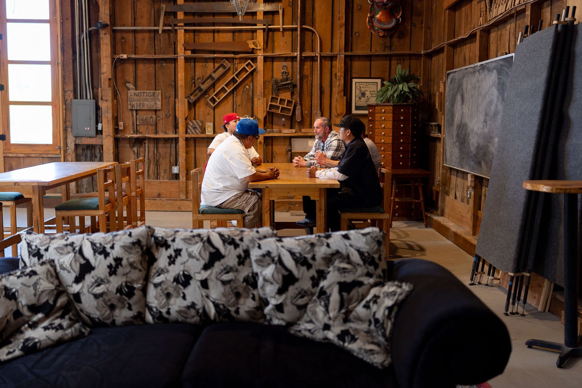 Man and woman in conversation on a couch; indoor setting.