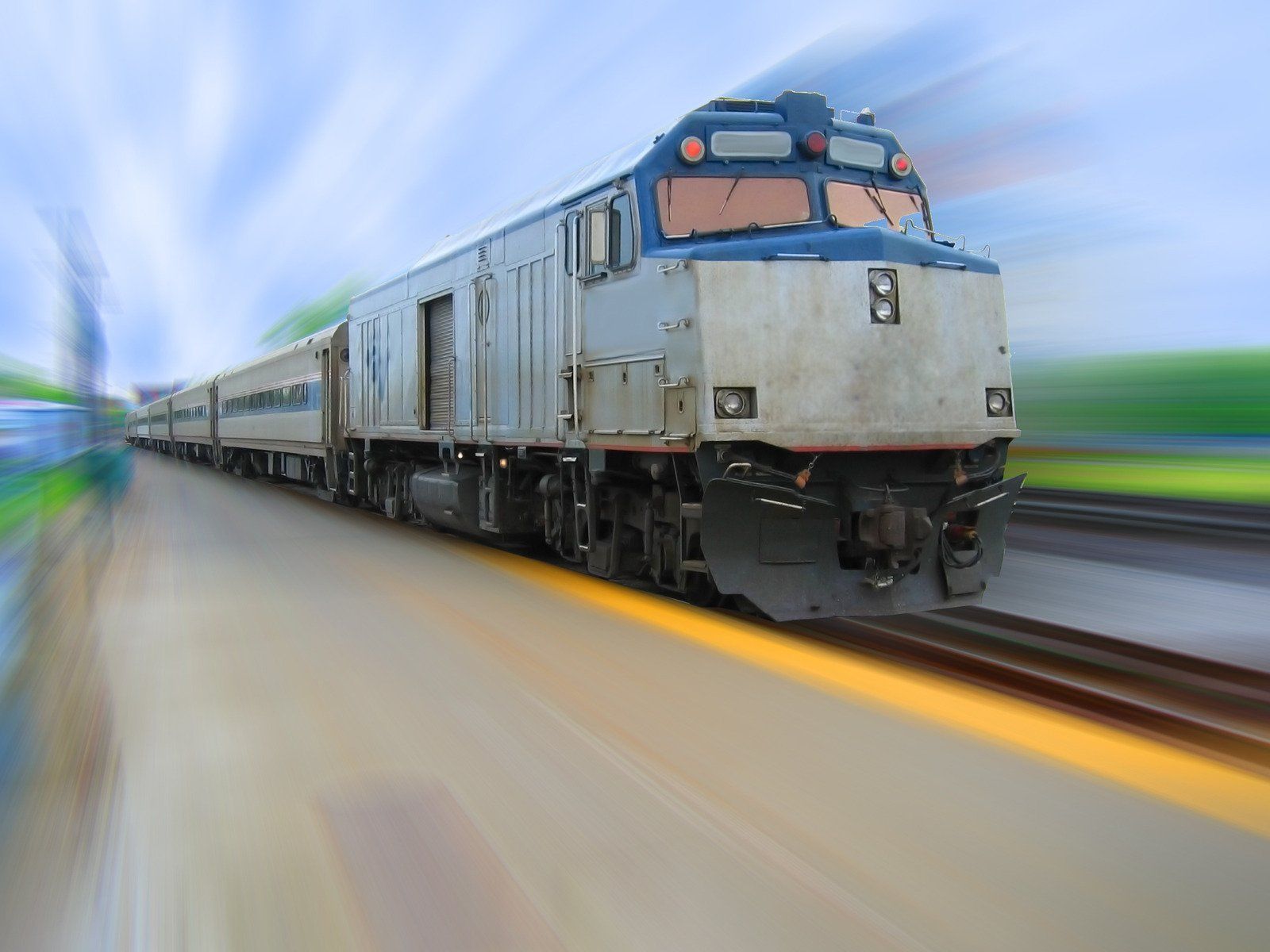 A train is coming down the tracks at a station.