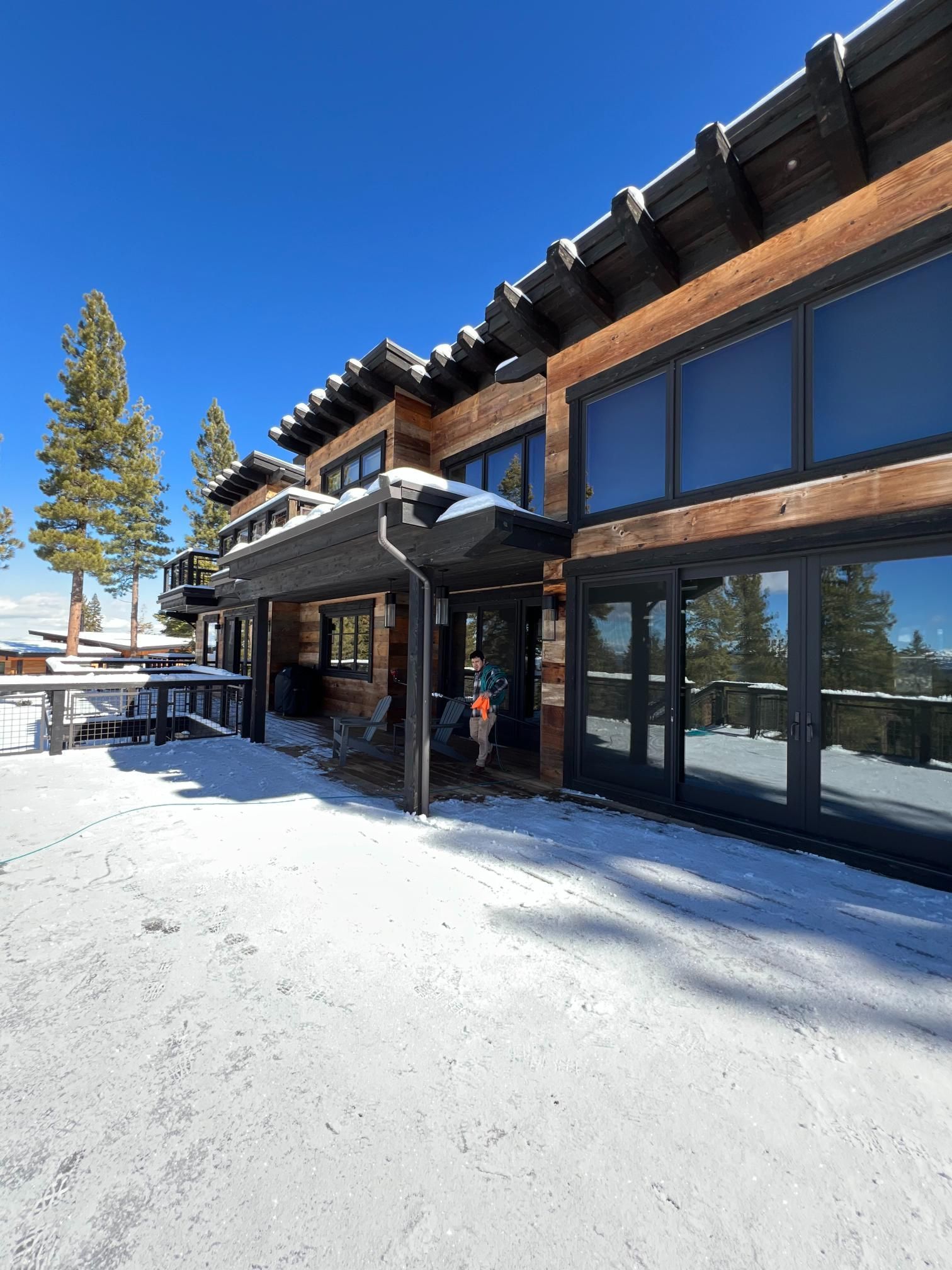 A large house with a lot of windows is covered in snow