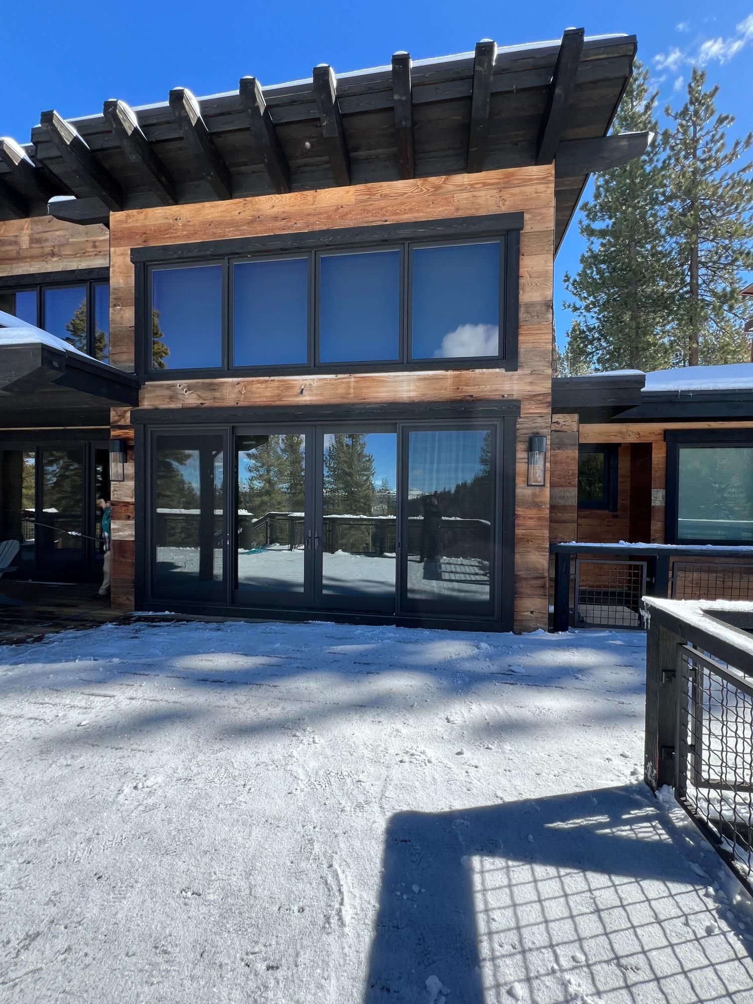A large house with a lot of windows is covered in snow.