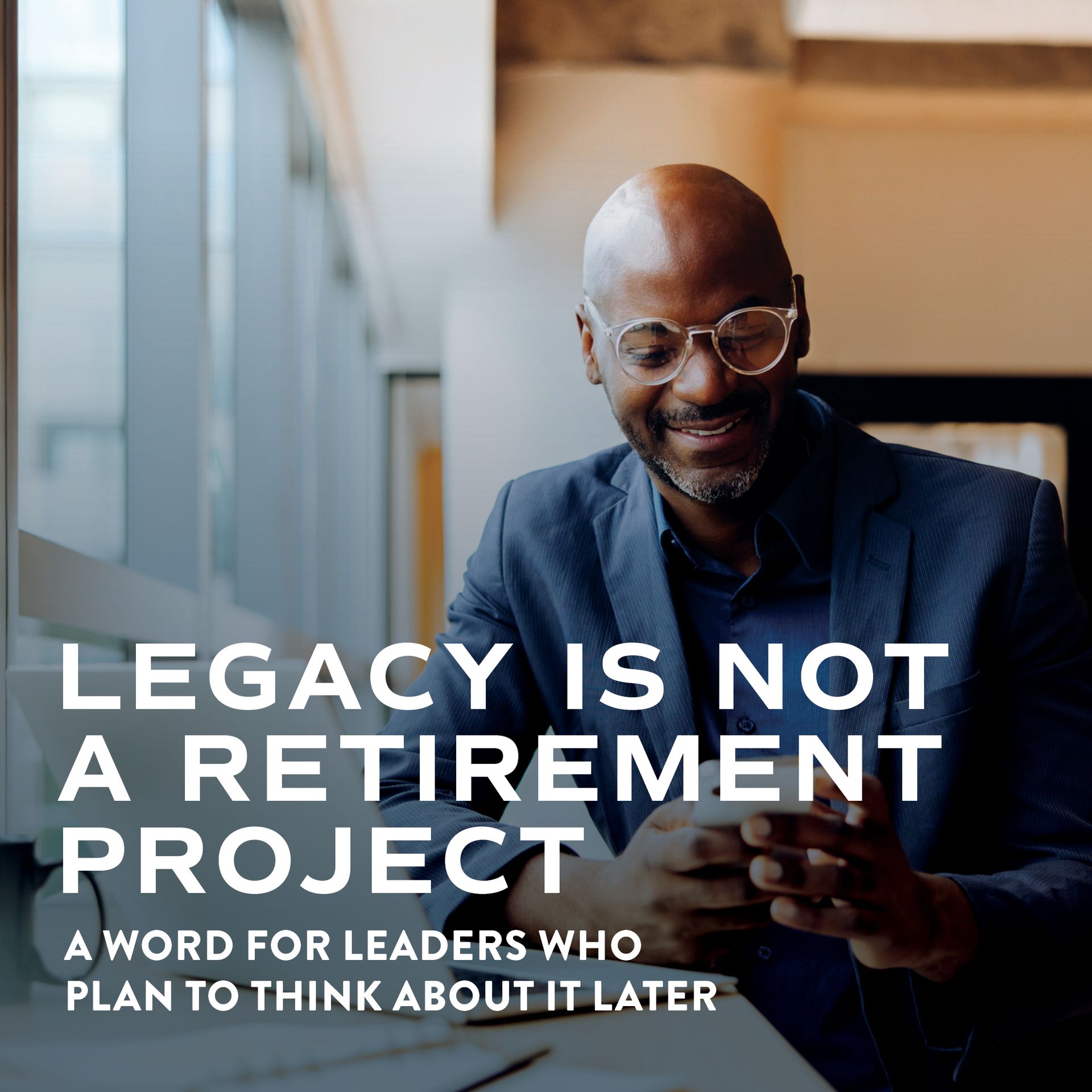 Man smiling while using a smartphone, with bold text: “Legacy is not a retirement project.”
