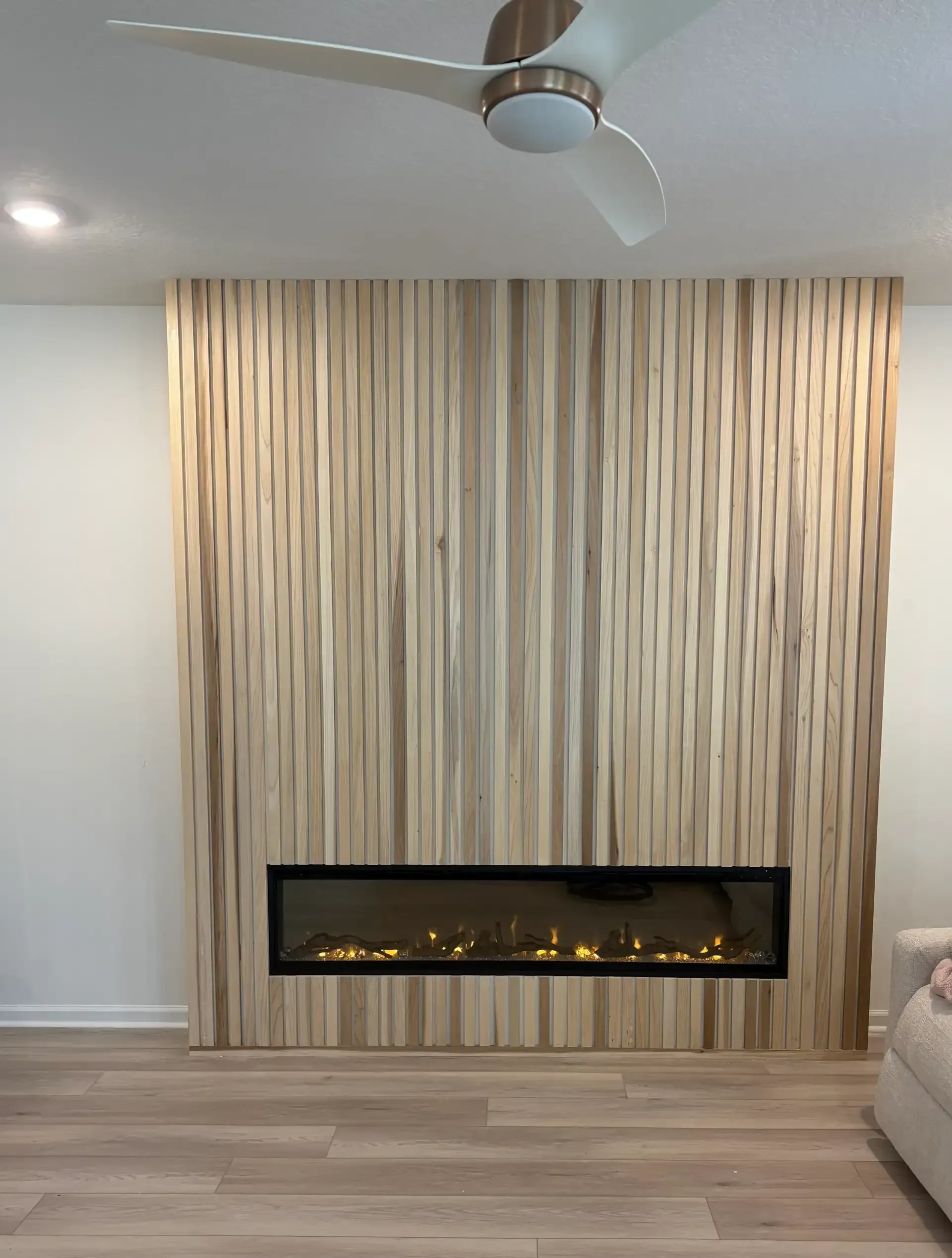 Modern slat wood accent wall with built-in fireplace