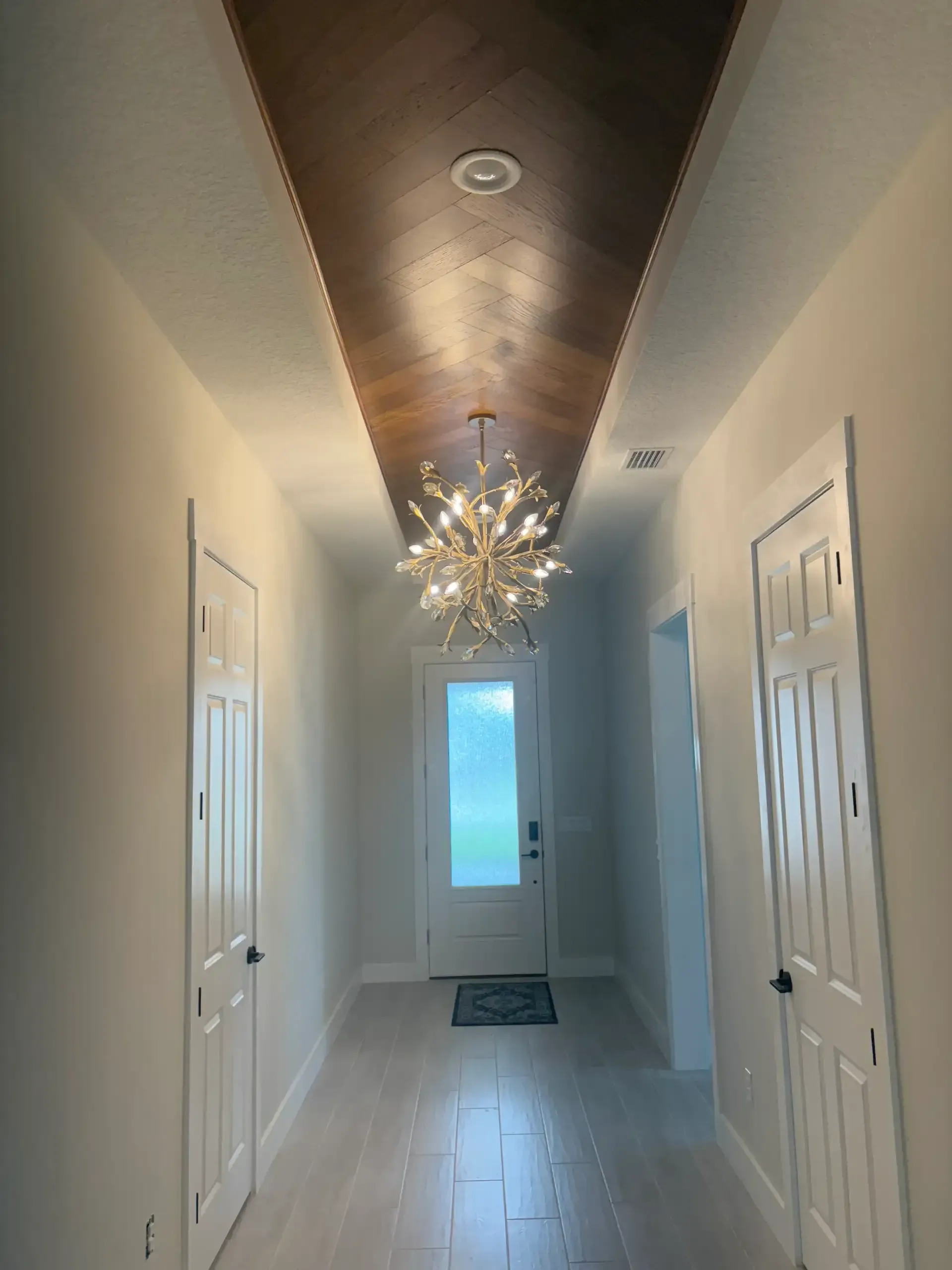 Hallway with wood ceiling detail and modern chandelier
