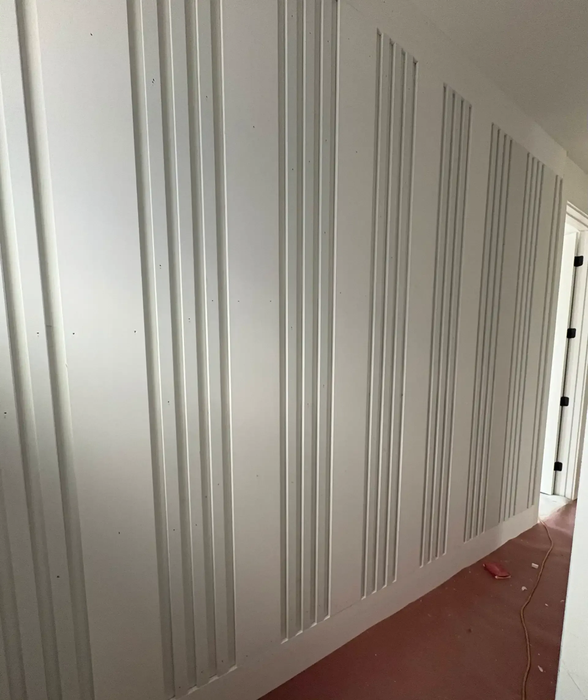 Hallway accent wall with vertical trim panel design