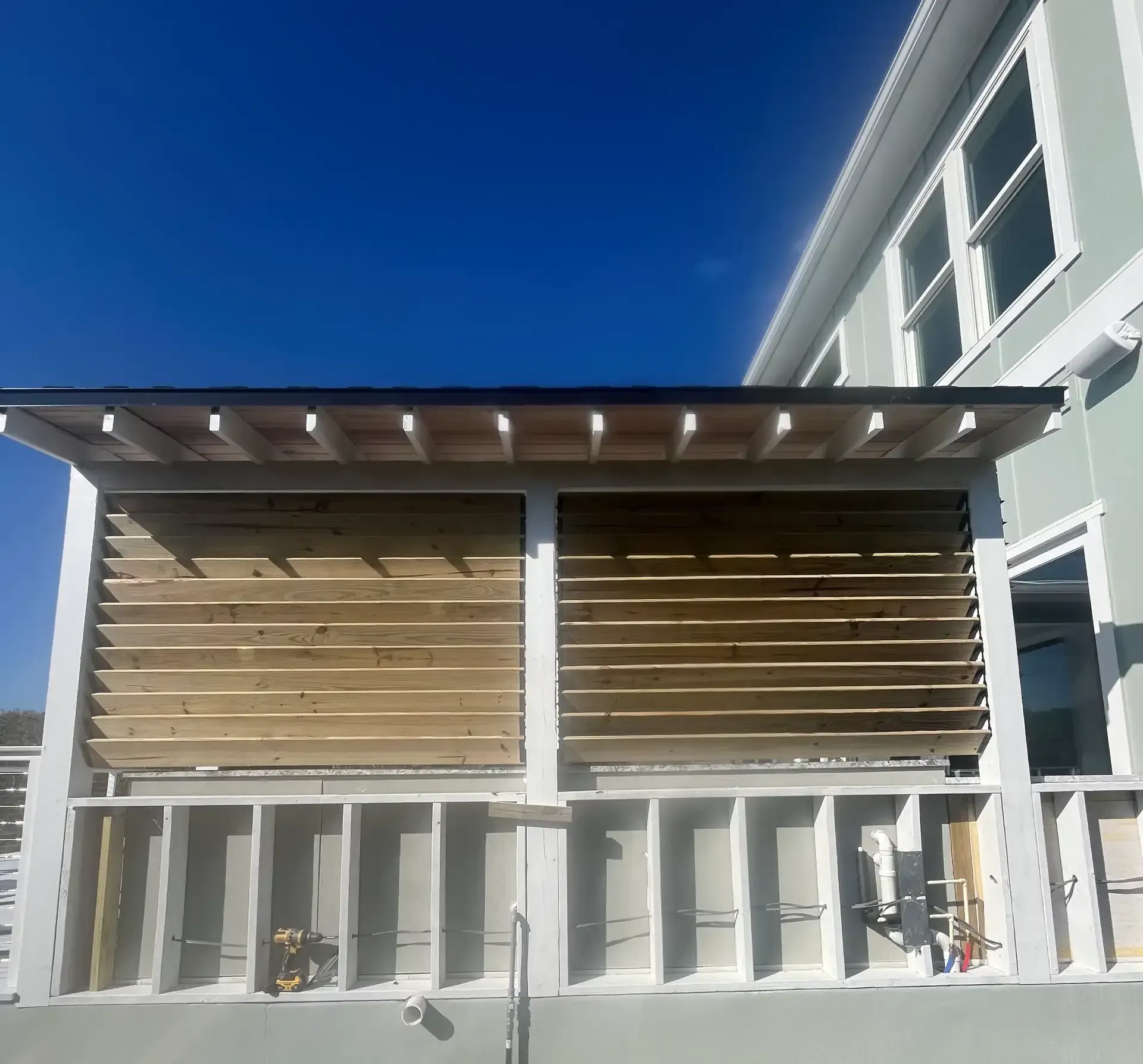 Outdoor porch wall with horizontal wood slats and framing