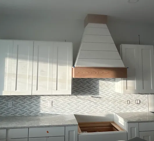 Shiplap range hood with wood trim above kitchen backsplash