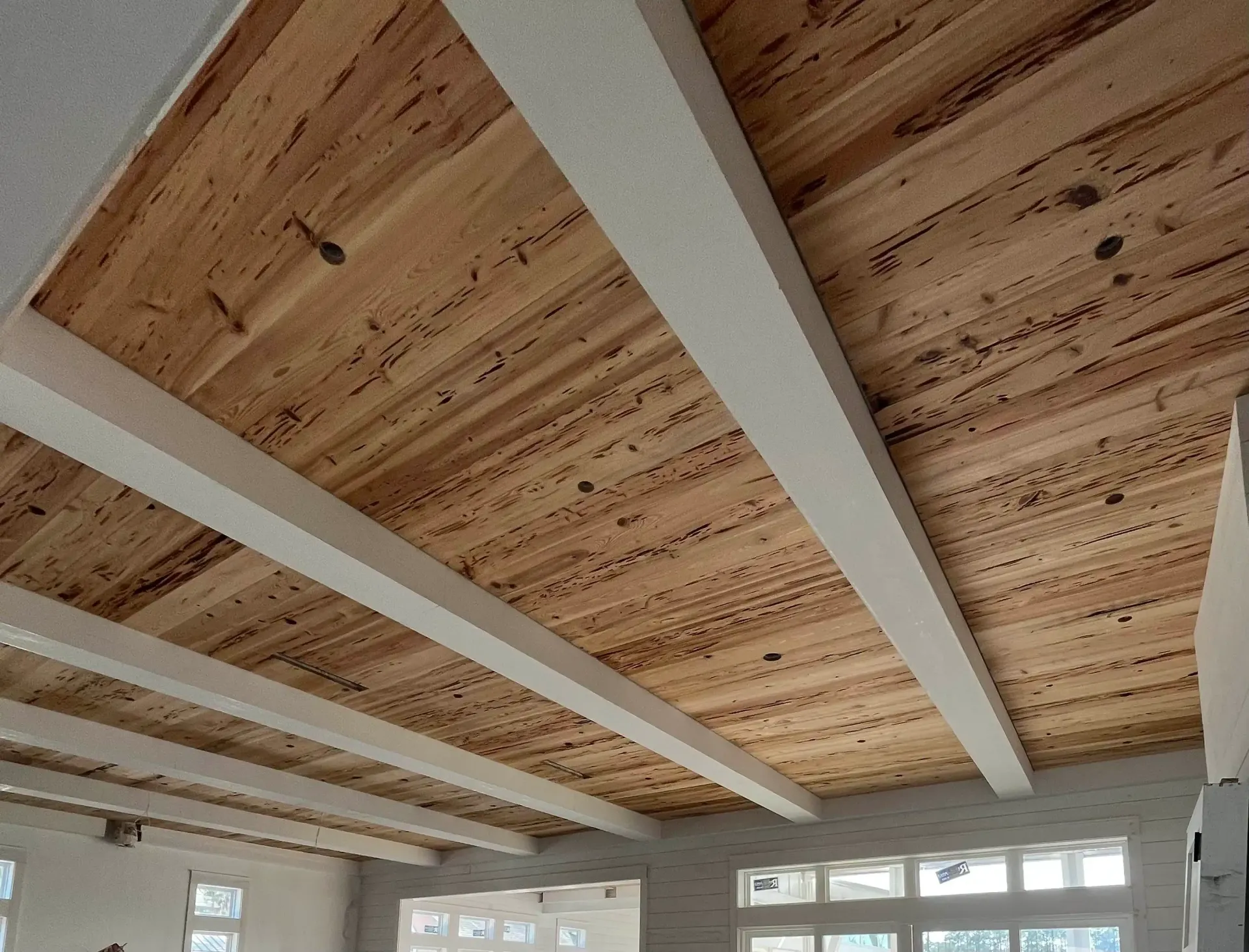 Wood plank ceiling with exposed beams and natural grain detail