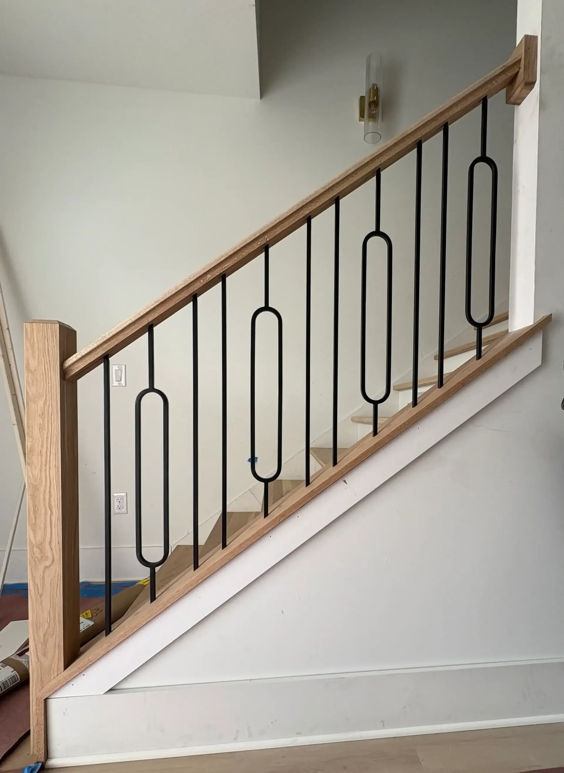 Modern wood handrail with custom black metal balusters