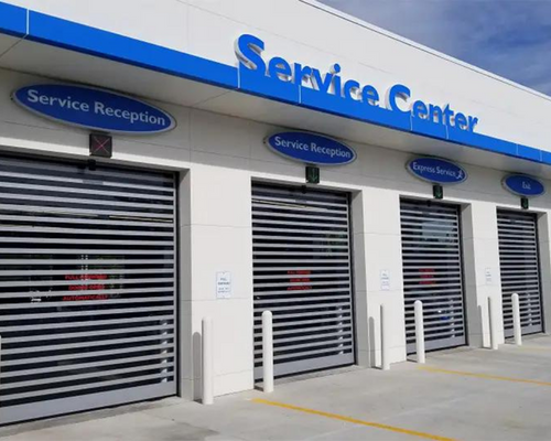 Service center exterior with silver roll-up doors and blue signage