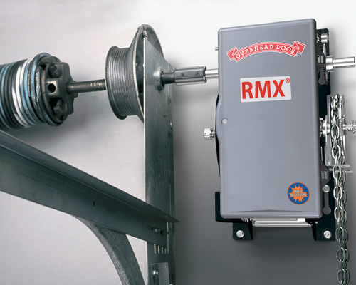 Gray industrial wall-mounted device labeled “RMX” attached to a metal shaft and pulley assembly