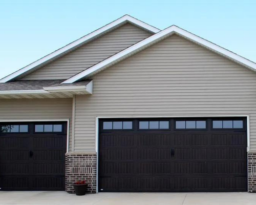 Two-car garage with beige siding, dark brown doors, and a gabled roof at a suburban home