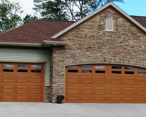 Stone house with brown double garage doors and a shingled roof