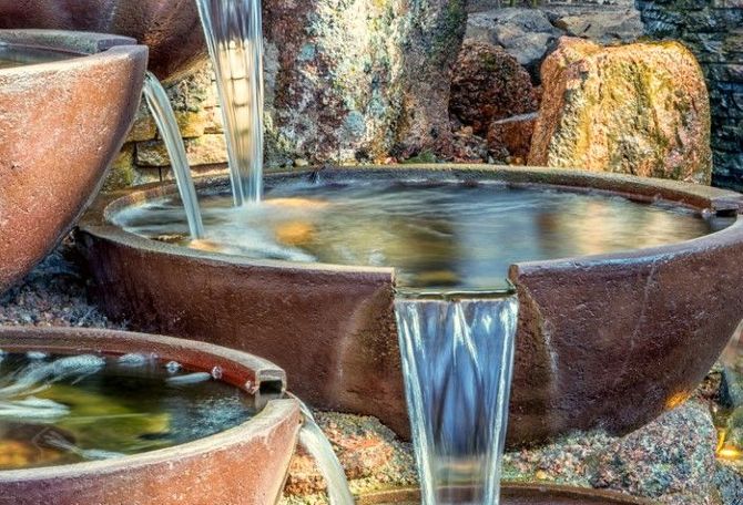 Stone fountain basins with flowing water and natural rocks surrounding them