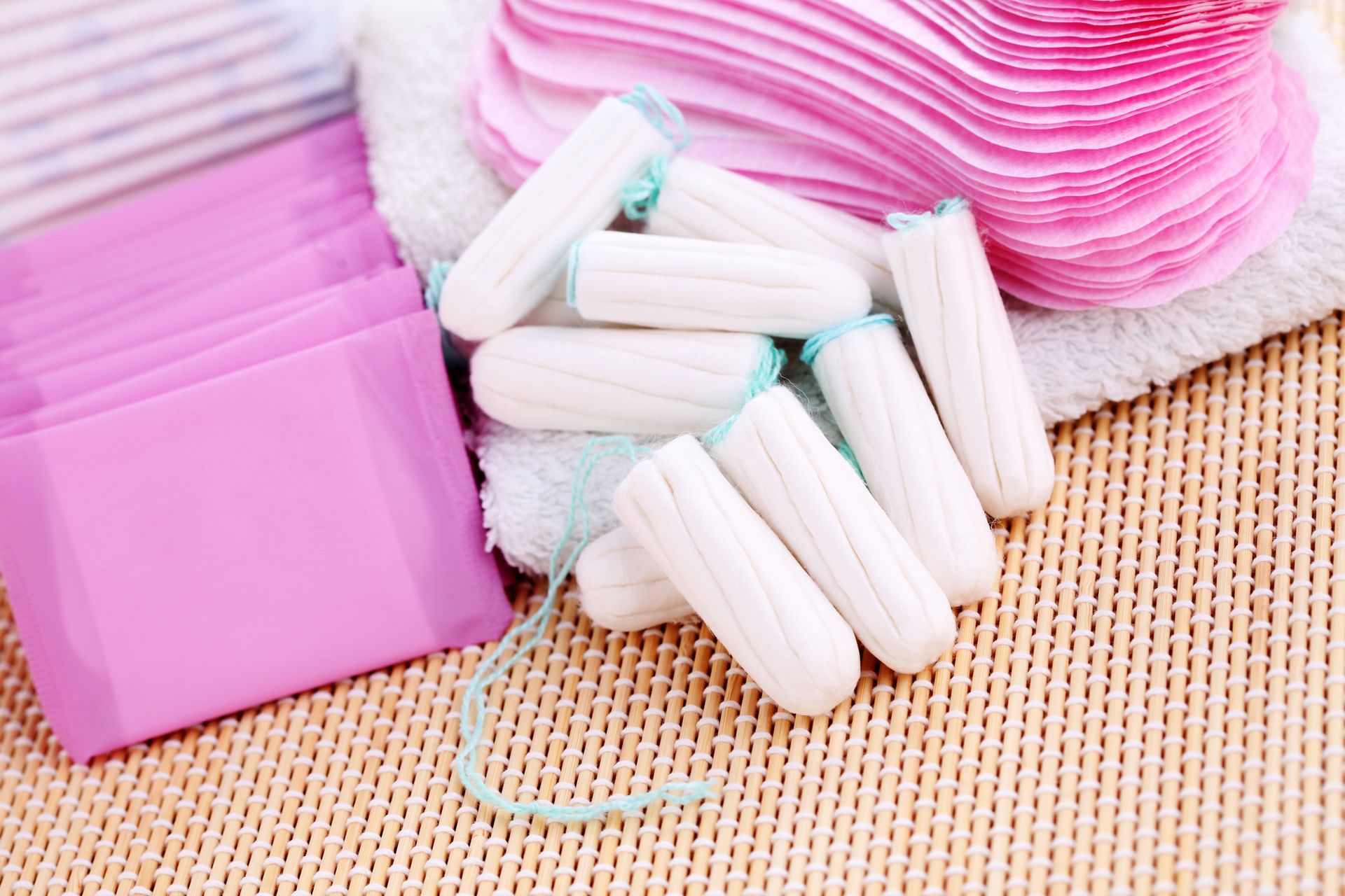 Pads and tampons on a pink background, providing feminine hygiene options.