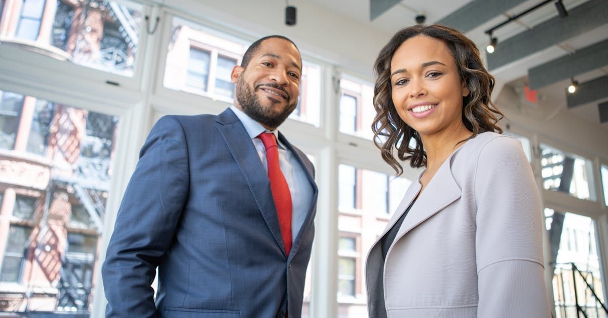 A man and a woman are standing next to each other in front of a window.