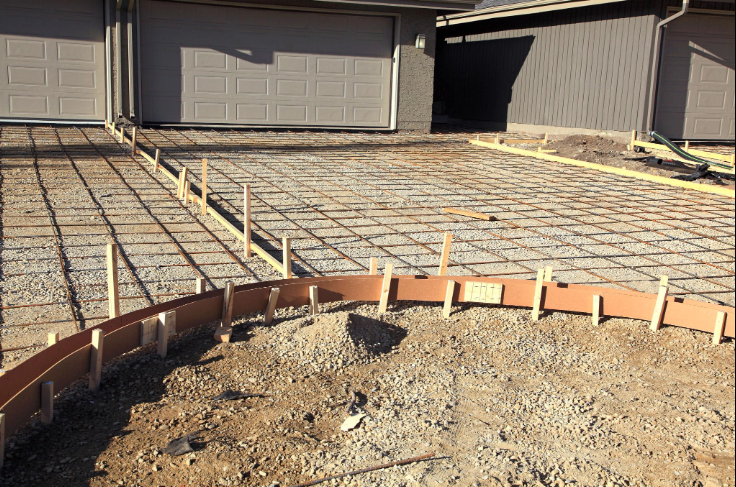 Newly poured concrete driveway with a broom-finish texture in front of a Four Corners FL home