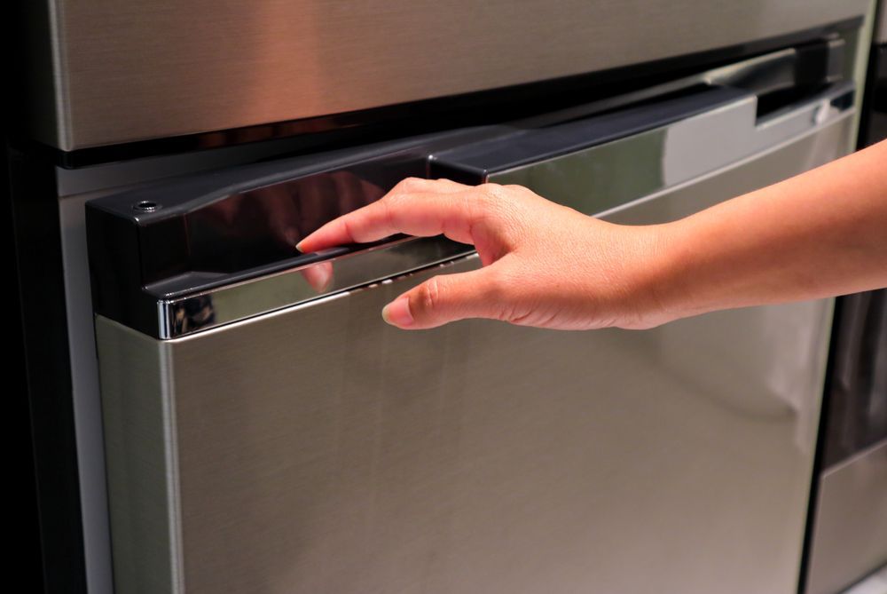 Hand Opening a Stainless Steel Dishwasher Door — Ace Fridge Door Seals In Cairns, QLD