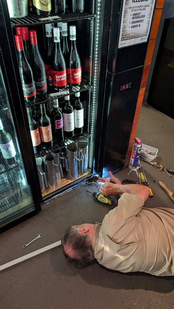 Person Lying on the Floor Beside a Glass Liquor Cooler — Ace Fridge Door Seals In Cairns, QLD
