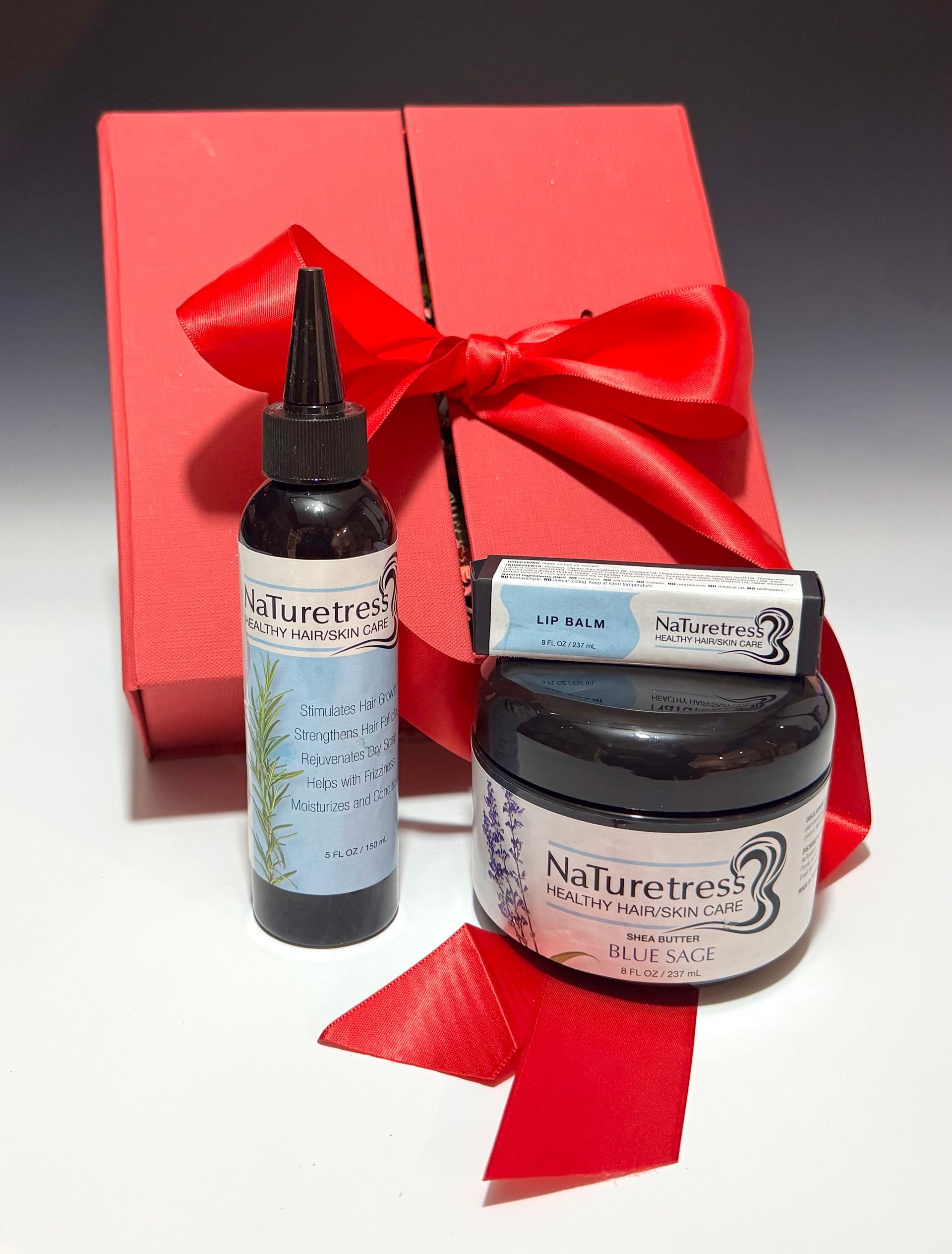 Black box with gray ribbon next to a jar of