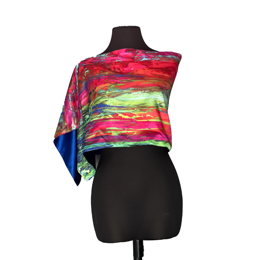 Colorful, abstract print silk scarf draped over a black mannequin, with a blue corner.