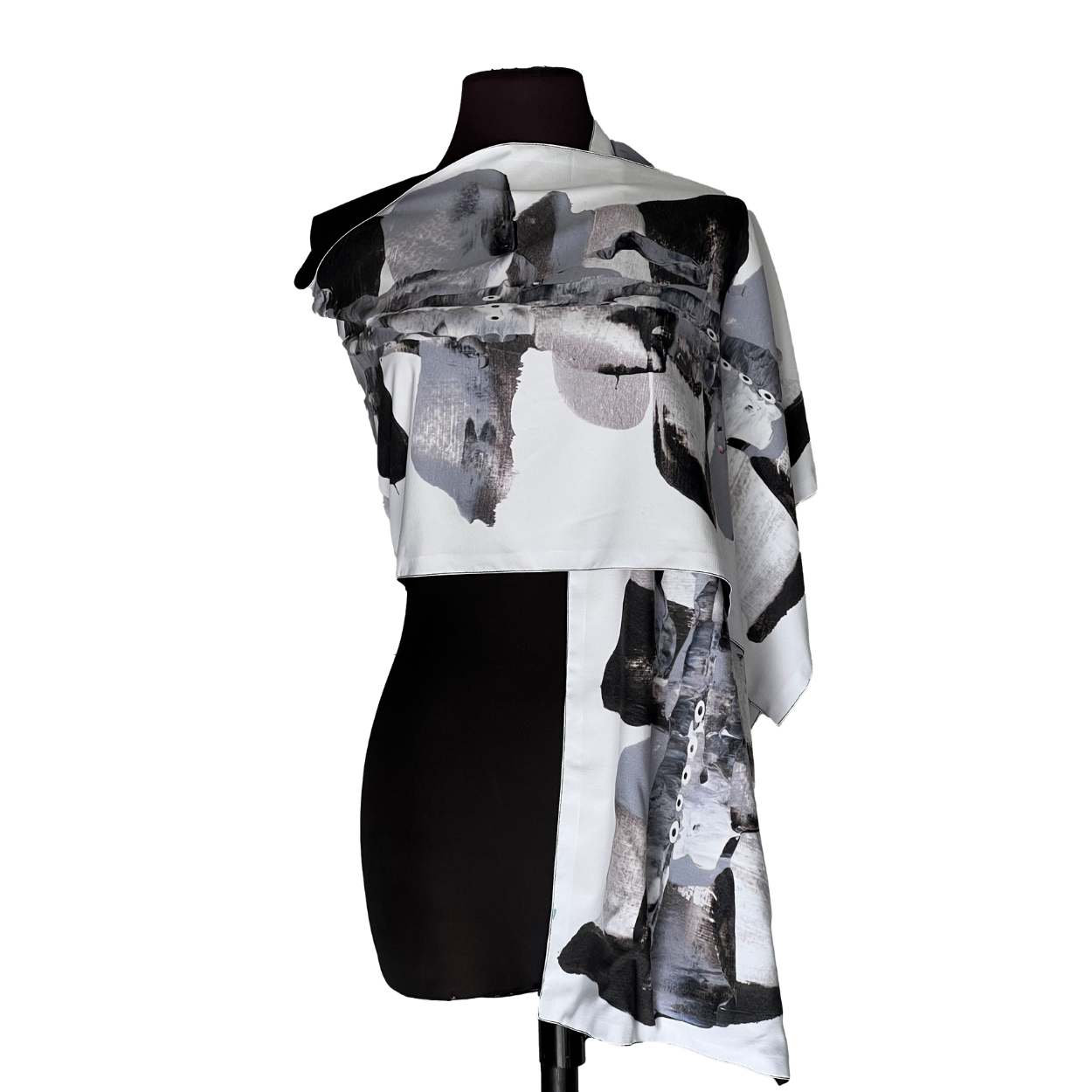Black mannequin wearing an abstract black-and-white draped off-shoulder dress