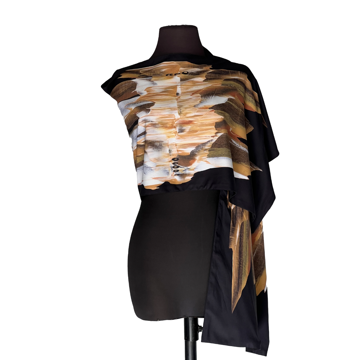 Black dress form wearing a draped abstract black, tan, and white top with a long side panel
